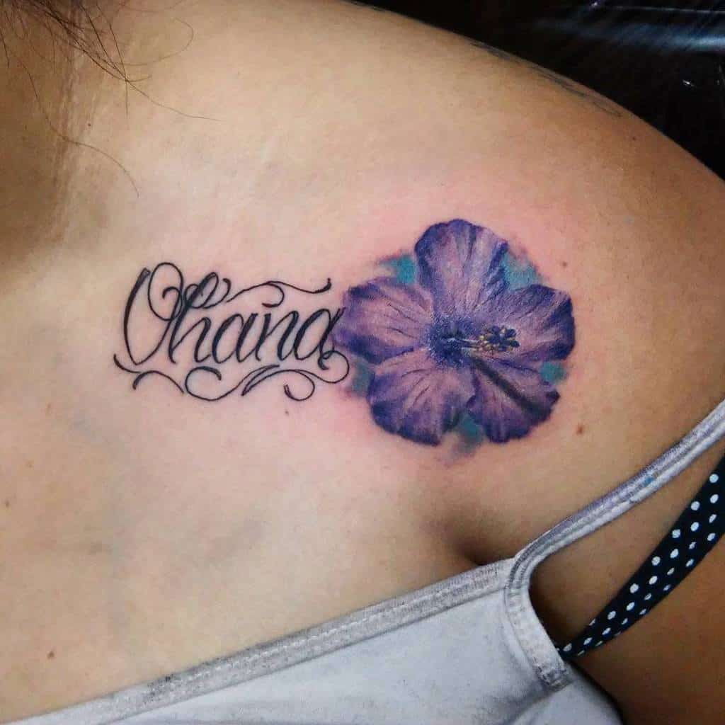 A shoulder tattoo of a purple flower next to the word "Ohana" in cursive script