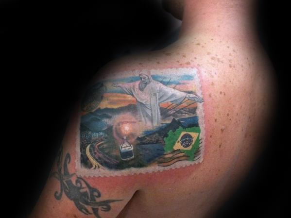 Vibrant tattoo of a Brazilian postage stamp featuring Christ the Redeemer and scenic landscapes.