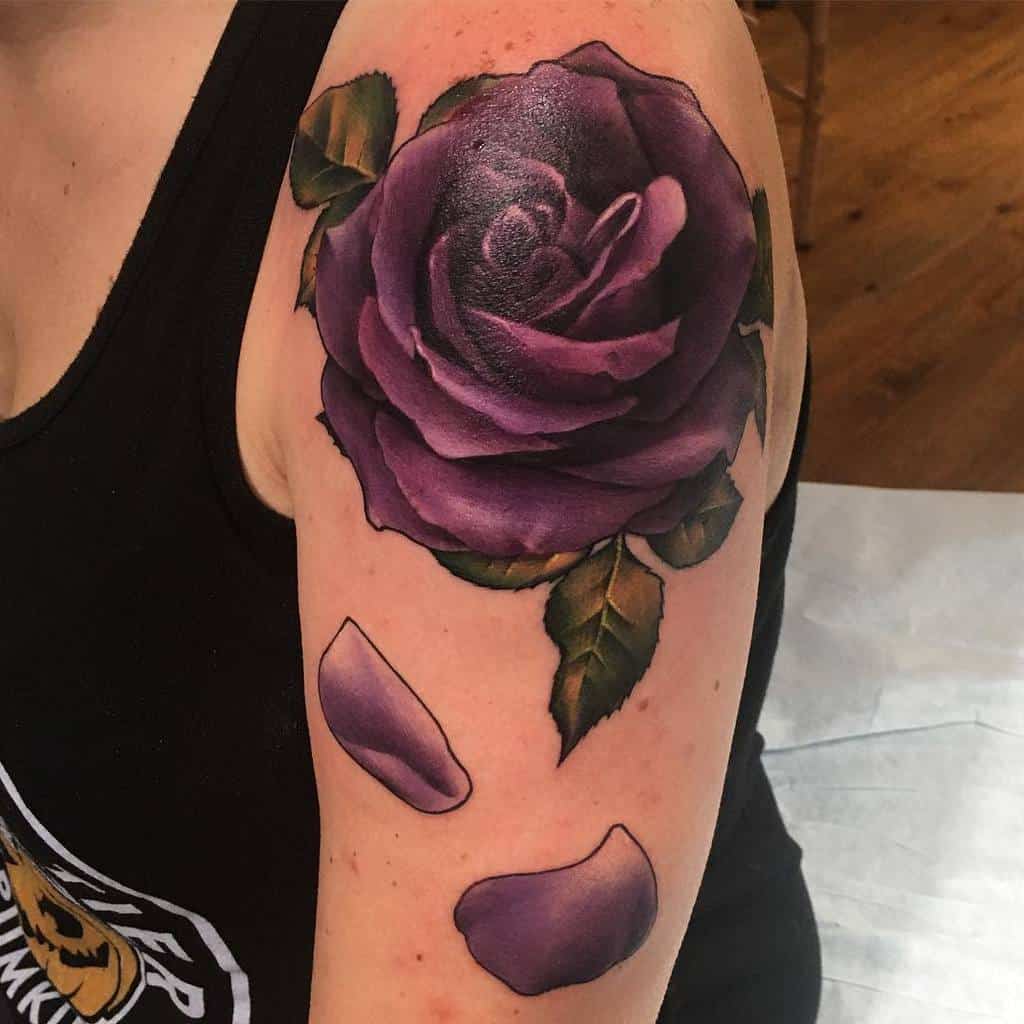 Arm tattoo of a realistic purple rose with petals and green leaves