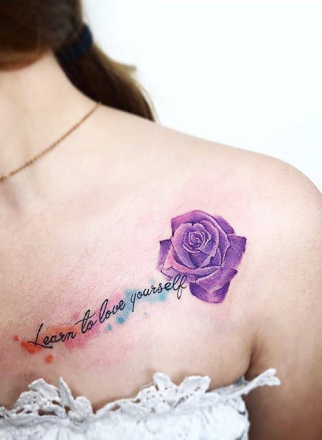 Tattoo of a purple rose and "learn to love yourself" on a woman's shoulder