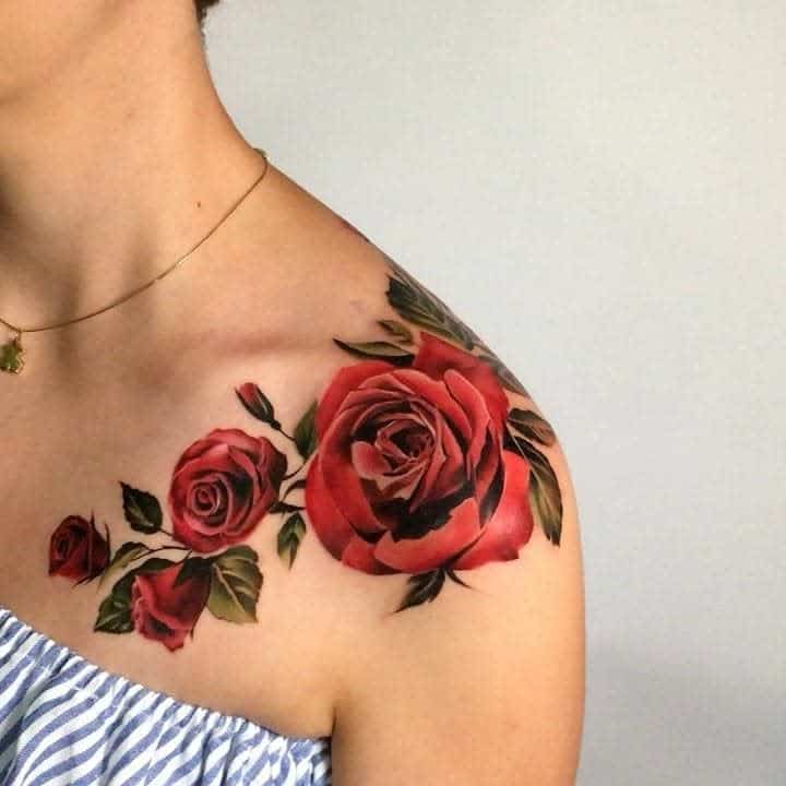 Woman's shoulder with a vibrant red rose tattoo
