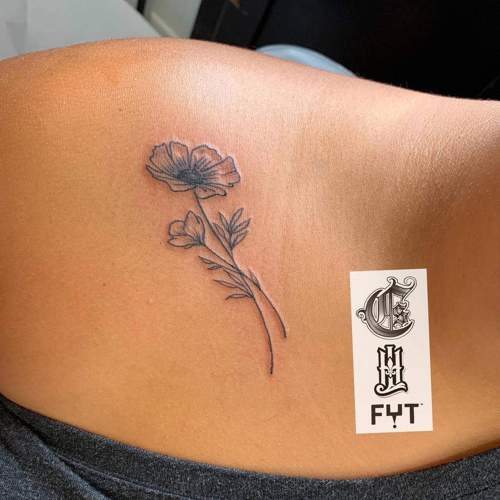 Tattoo of a blooming flower with leaves and a long stem