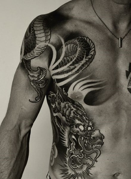 Man with intricate dragon and snake tattoos on chest and shoulder