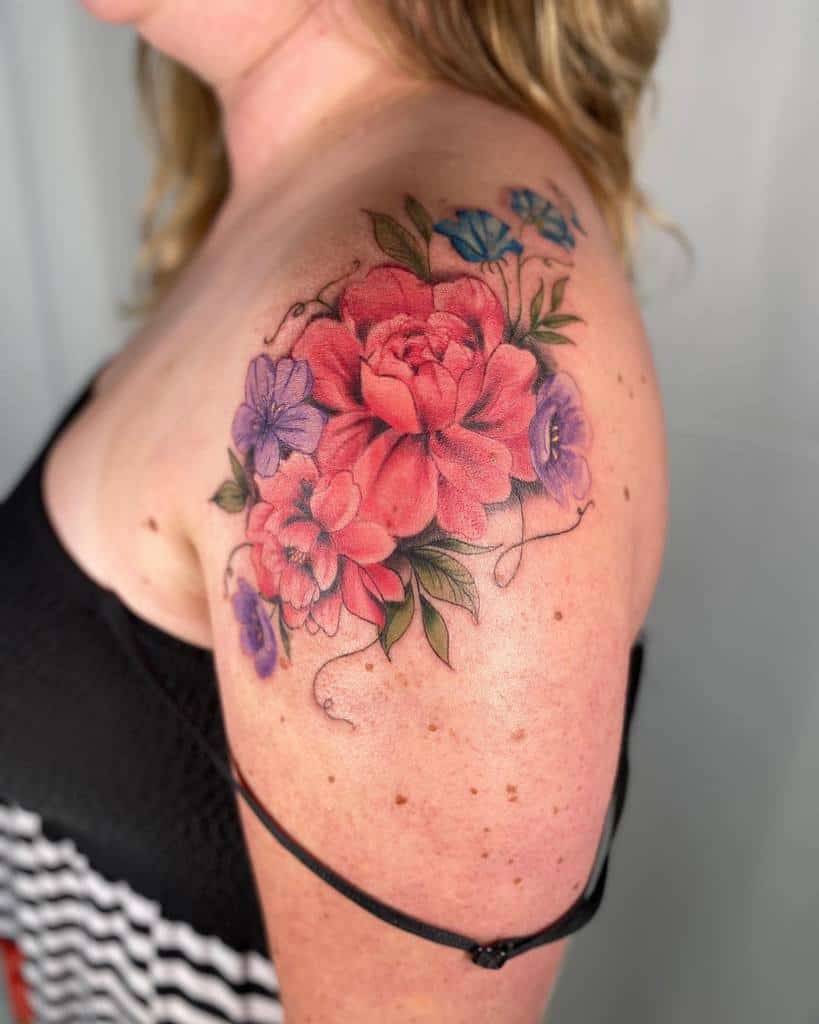 Woman with a colorful floral tattoo on her shoulder and upper arm