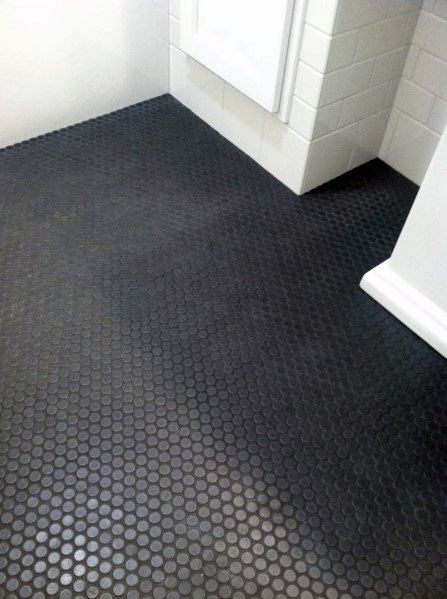 Modern room with a black hexagonal tile floor and white shower tiles