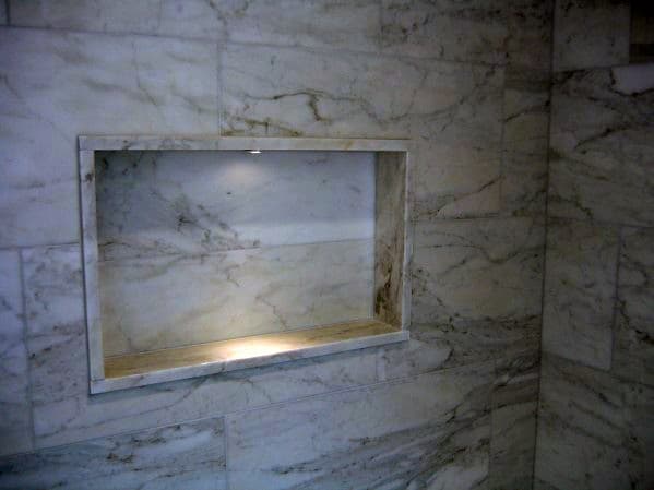 Elegant marble shower with a recessed niche shelf, featuring soft LED accent lighting for a refined touch