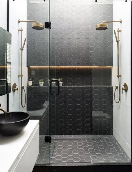 lack hexagonal tile shower with dual brass showerheads and glass enclosure.