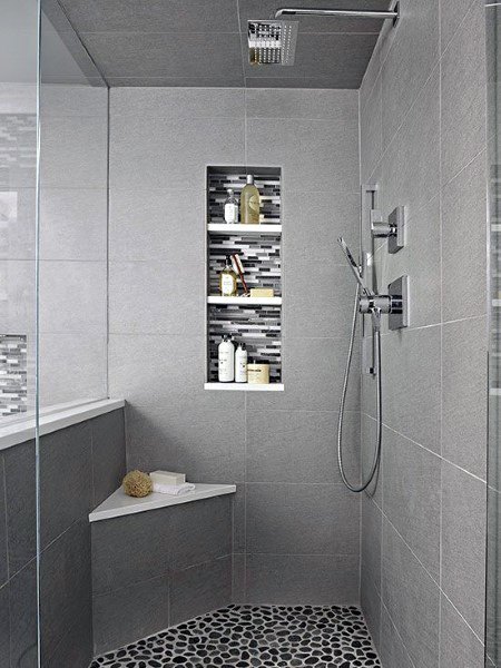 Grey porcelain tile shower with pebble floor, mosaic niche, and built-in corner bench.