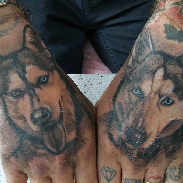 Realistic Siberian Husky tattoos on both hands, featuring detailed fur shading, expressive blue eyes, and lifelike facial expressions for a bold design.