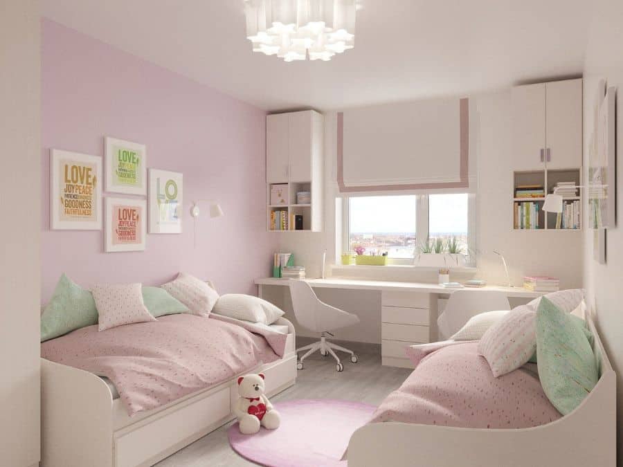 twin beds kids room pink hues white desk and cabinets
