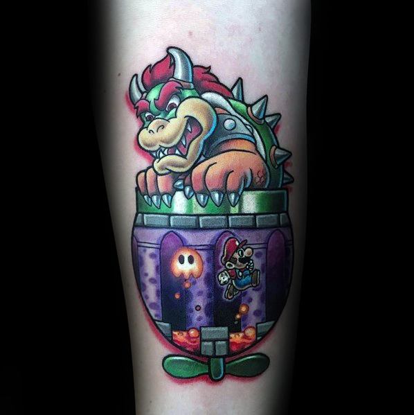 Colorful Bowser tattoo on a man's forearm featuring bold outlines, vibrant shading, and a detailed Clown Car with Mario in a fiery scene.