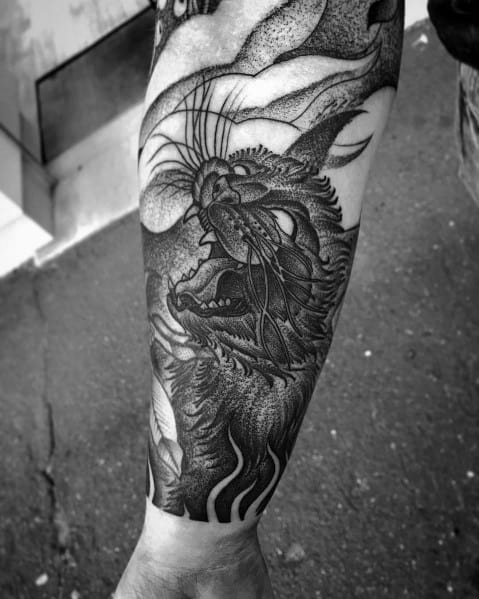 Intricate blackwork tattoo of a roaring wild cat with bold shading and dynamic details, creating a fierce and powerful design.