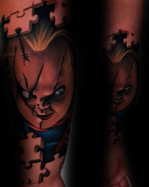 Realistic Chucky tattoo with a unique puzzle piece effect, featuring his sinister grin, stitched face, and intense shading for a bold horror design.