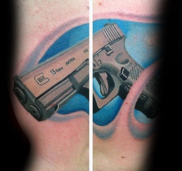 Colorful tattoo of a Glock 19 split across both sides of the chest, featuring a bold blue background and detailed shading for a three-dimensional effect.