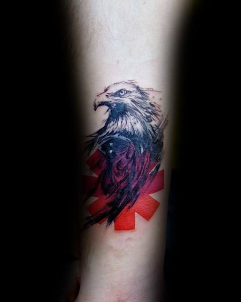 Tattoo featuring a fierce black and grey eagle over the Red Hot Chili Peppers logo, blending bold shading with red accents for a powerful design.