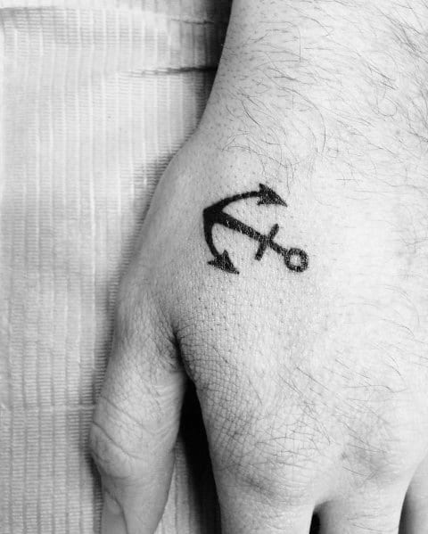 Small black anchor tattoo on the hand with a bold and simple design, symbolizing strength, stability, and a deep nautical connection.
