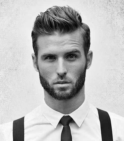 Voluminous quiff with a defined side part and a clean, tapered fade