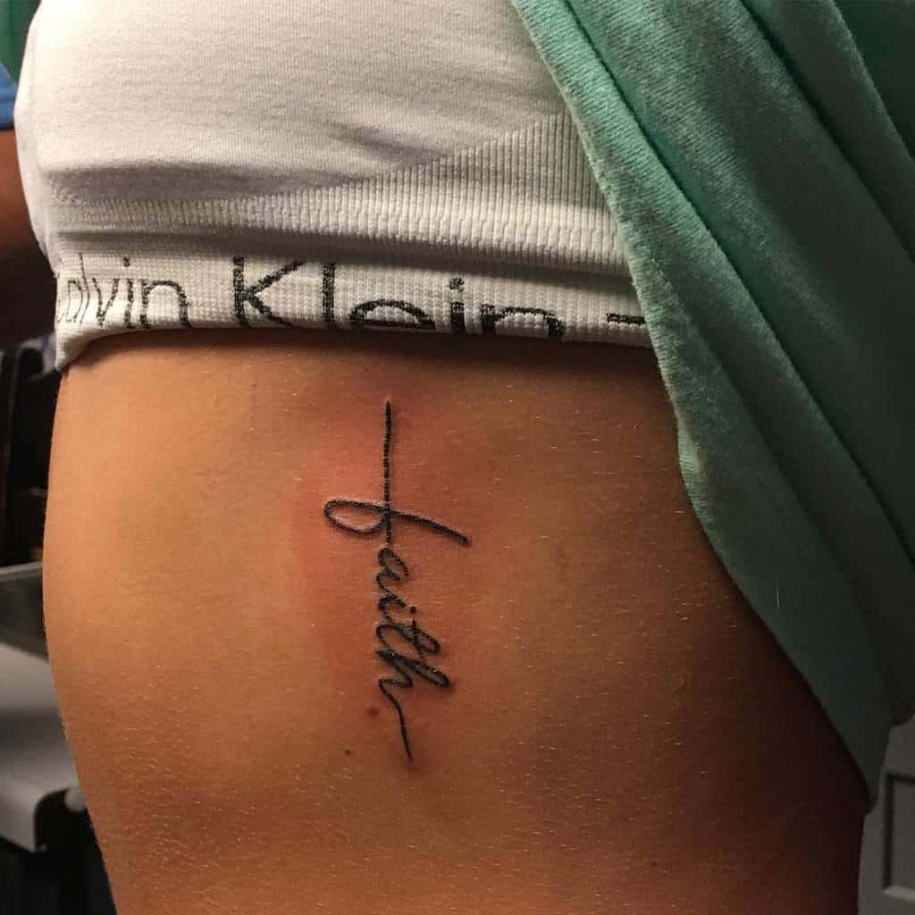 A tattoo of the word "faith" elegantly graces a person's side
