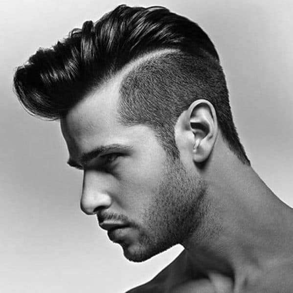 High pompadour with a sharp side part and a clean undercut fade