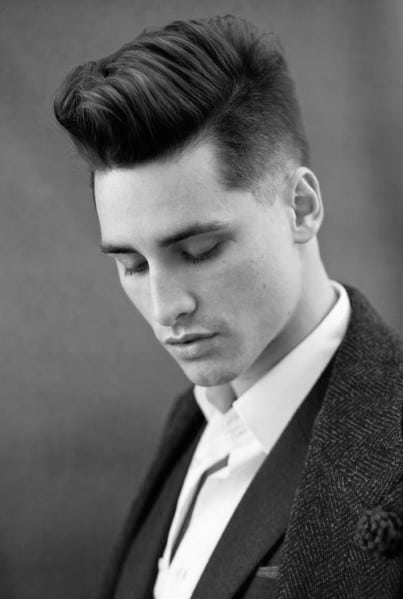 Sleek, high-volume pompadour with a clean side part and a tapered fade