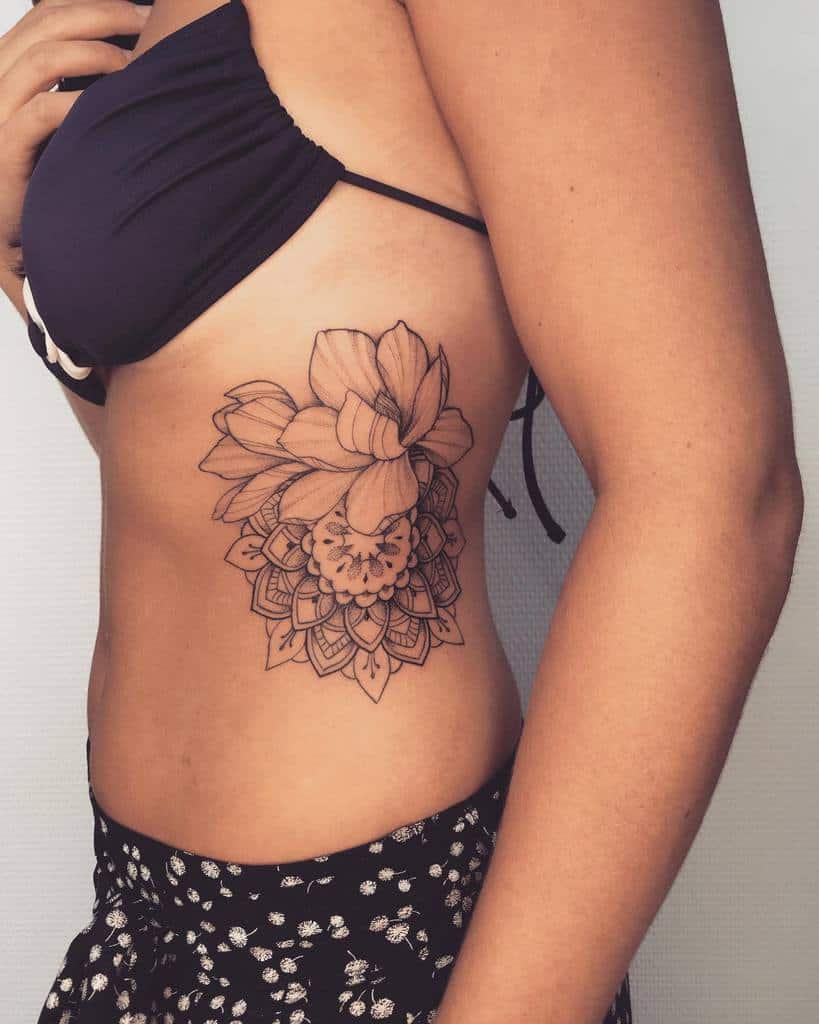 A stunning magnolia tattoo design graces a woman's side