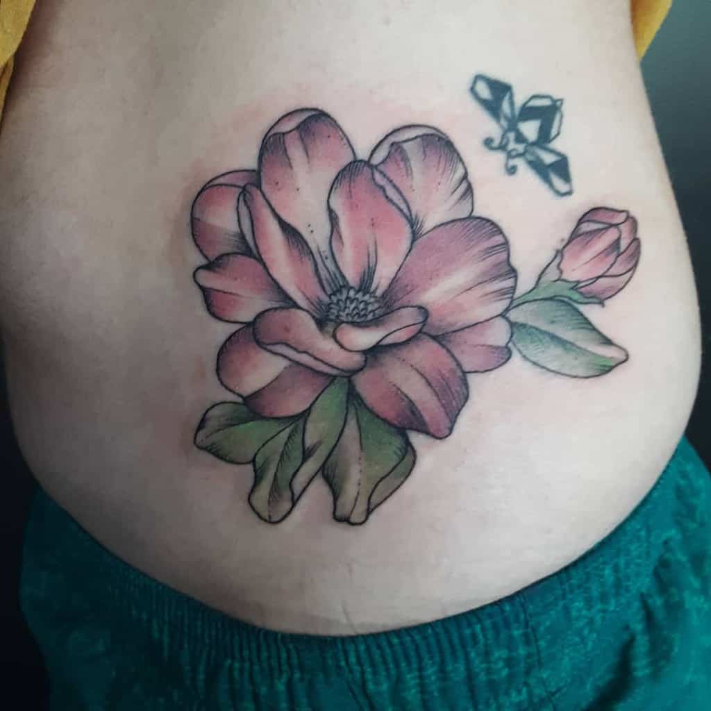 Tattoo of a pink magnolia flower with green leaves and a small butterfly gracefully perched on the skin
