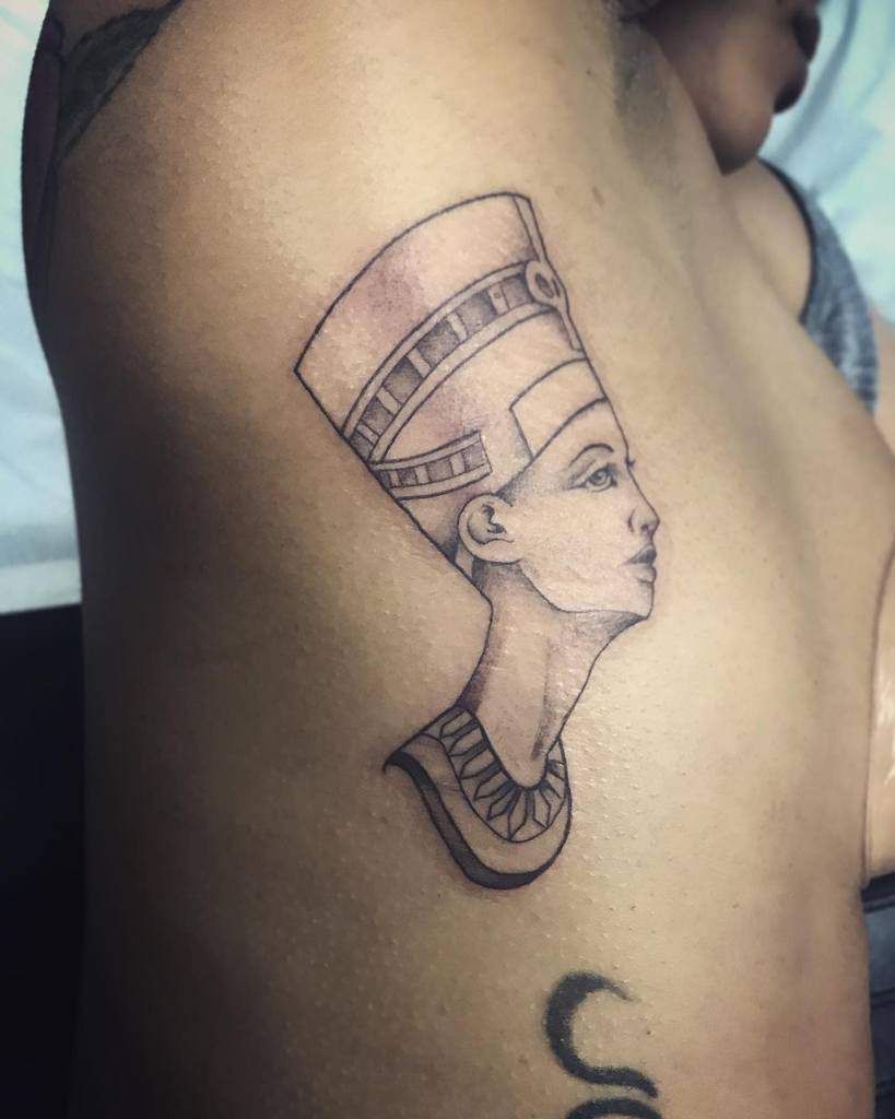 Outline tattoo of an ancient Egyptian queen's head and shoulders on a side torso