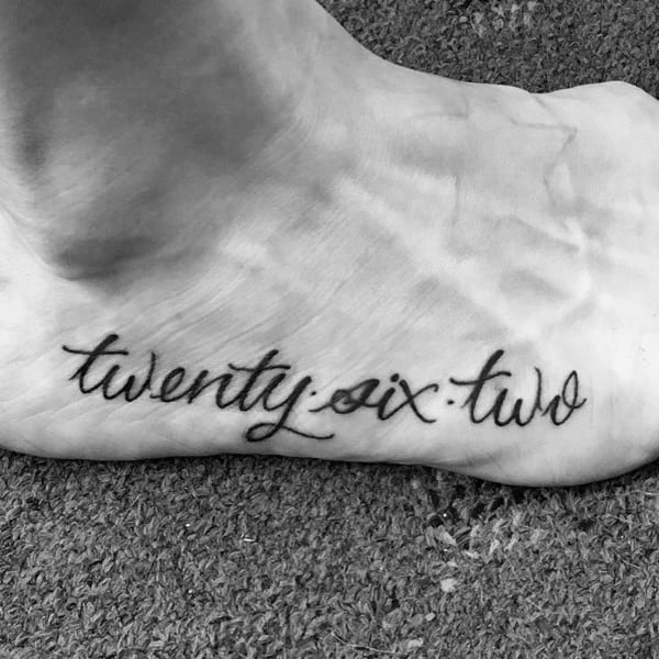Cursive “twenty.six.two” tattoo elegantly placed on the foot, a stylish and personal tribute to completing a marathon.