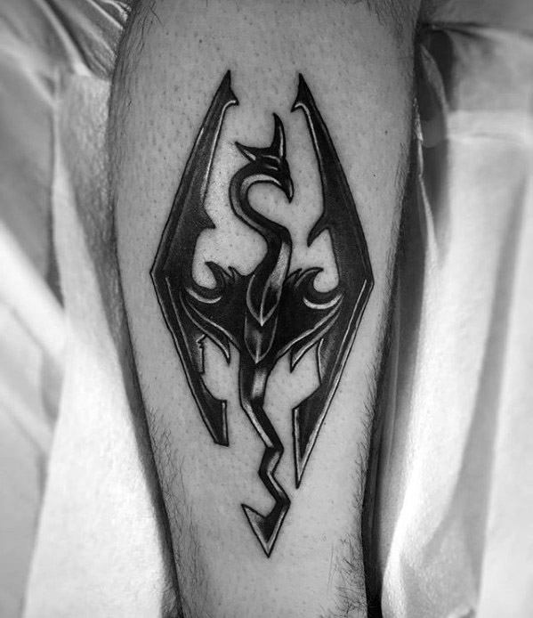 Black and gray Skyrim dragon emblem tattoo with bold shading and sharp edges, perfectly centered on the calf