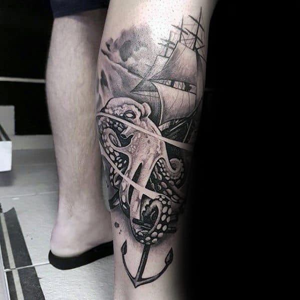 Leg tattoo of an octopus entwined around an anchor with a sailing ship in the background