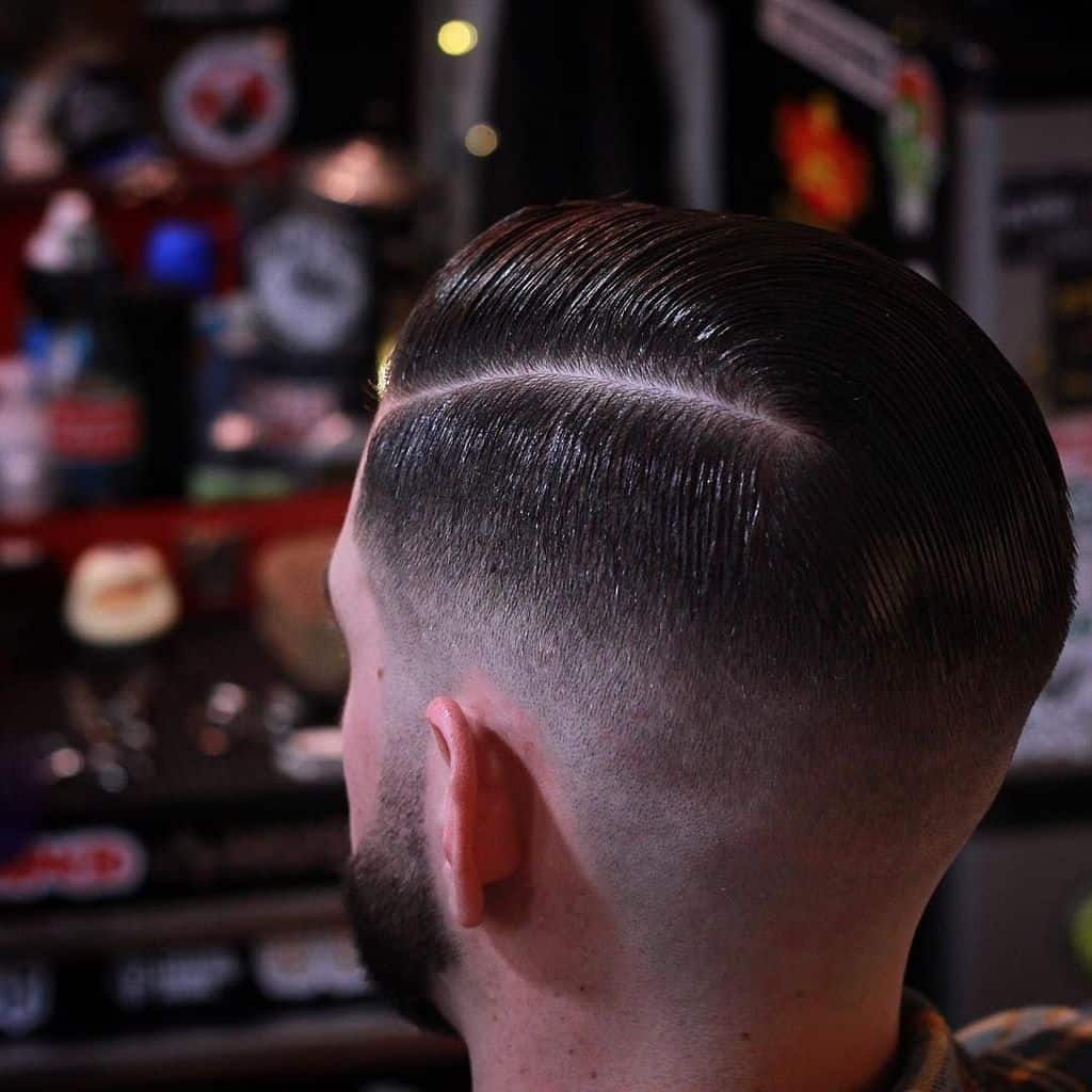 A burst fade haircut with side parted hair and barely noticeable fade transition