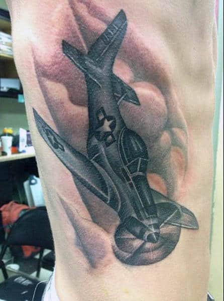 Tattoo of a WWII airplane on a person's ribs with clouds in the background