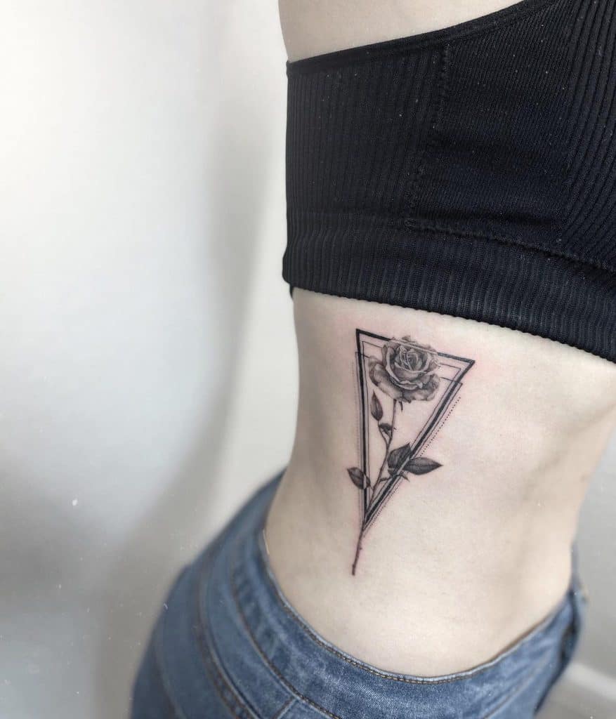 A tattoo of a rose inside a triangle is on woman's side 