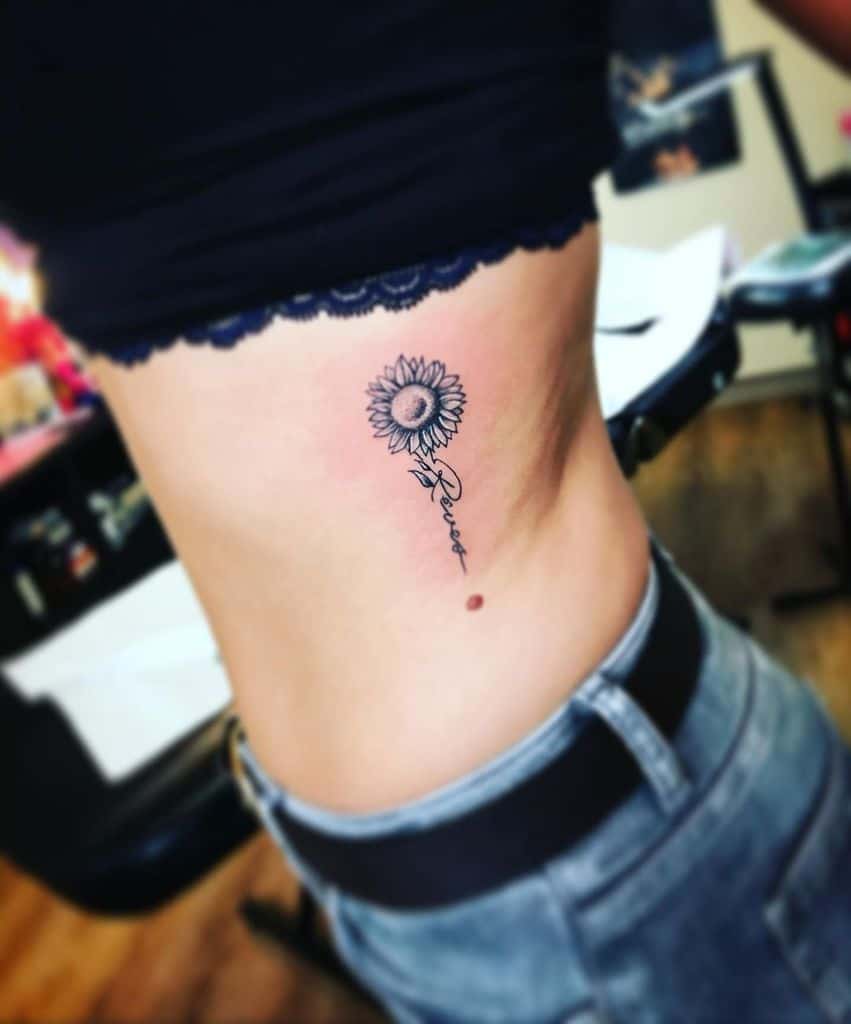 A sunflower tattoo on a person's side