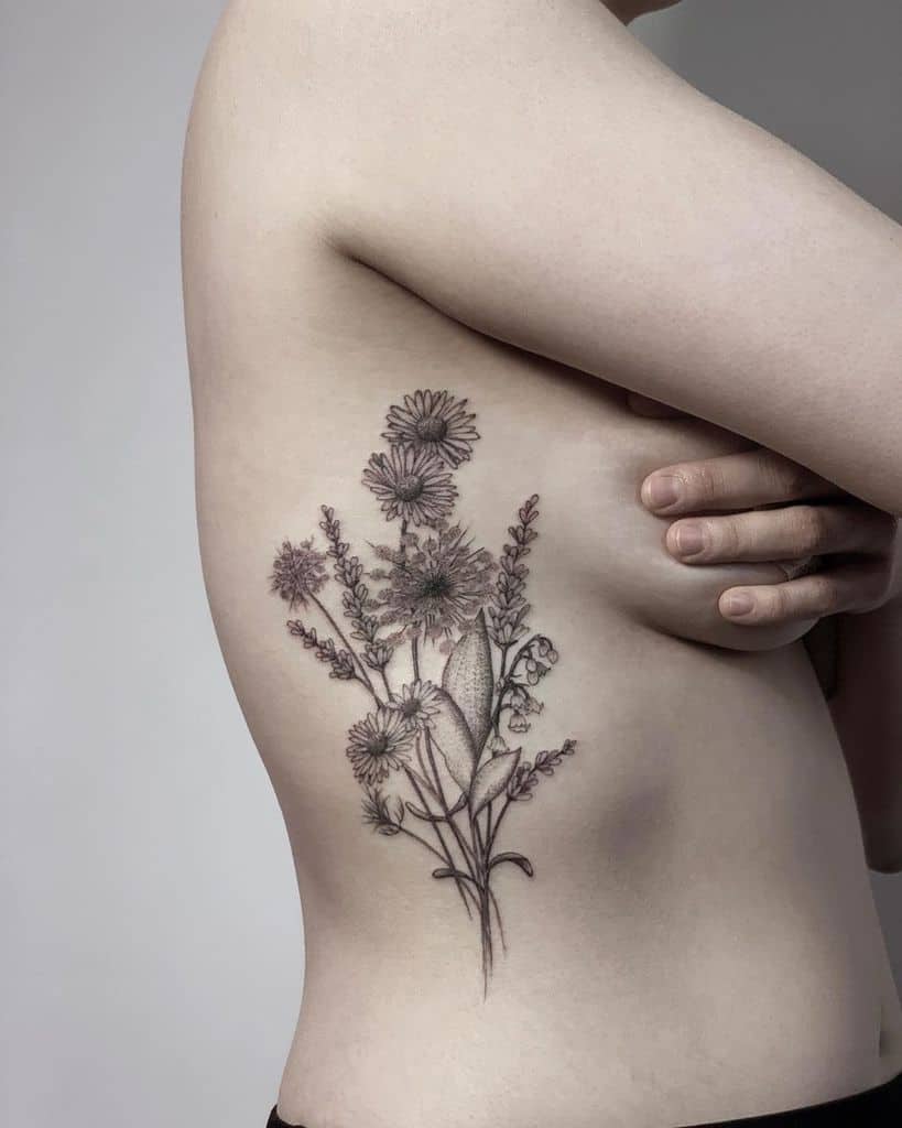 A person with a floral tattoo on their side, featuring intricate flowers and leaves