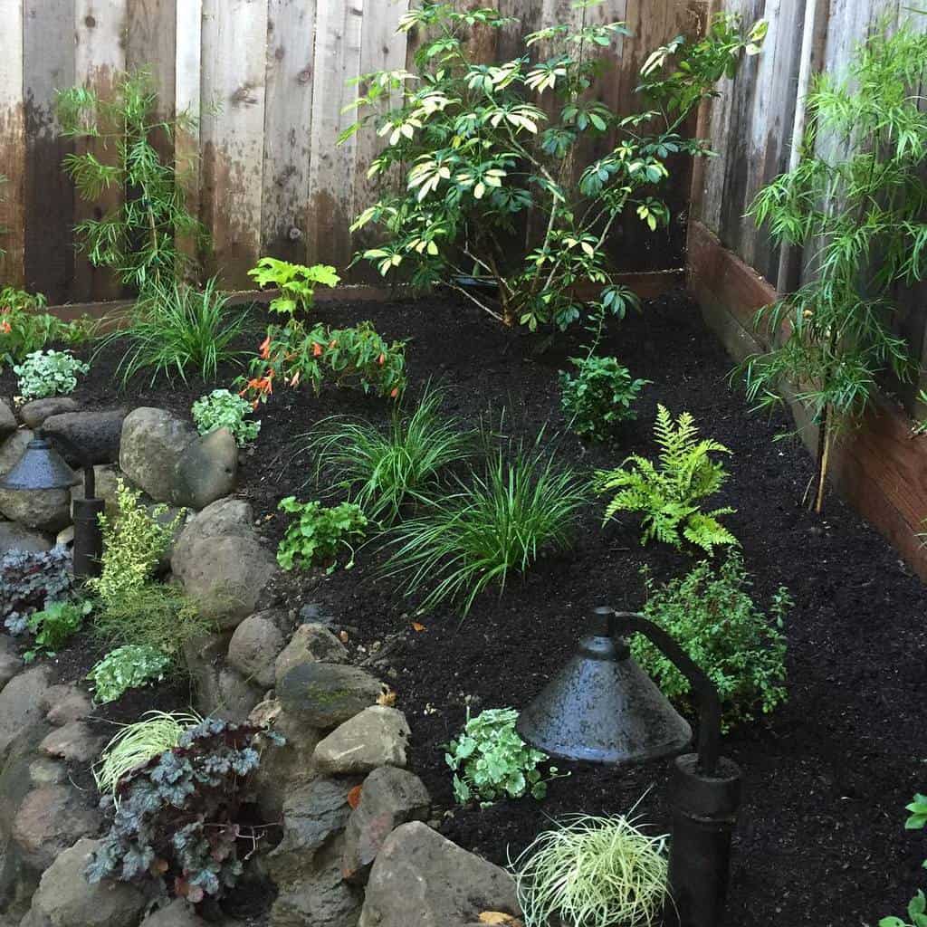 small corner garden with rock retaining wall
