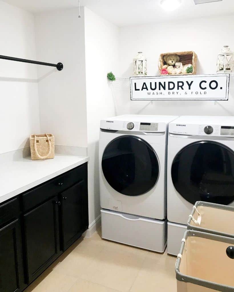 simple white laundry with black cabinets and washer and dryer