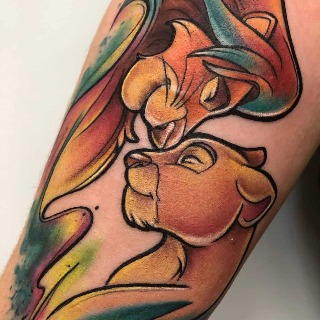 Vibrant tattoo of Simba and Nala, their faces intertwined with colorful, flowing accents, capturing their love and unity with bright hues