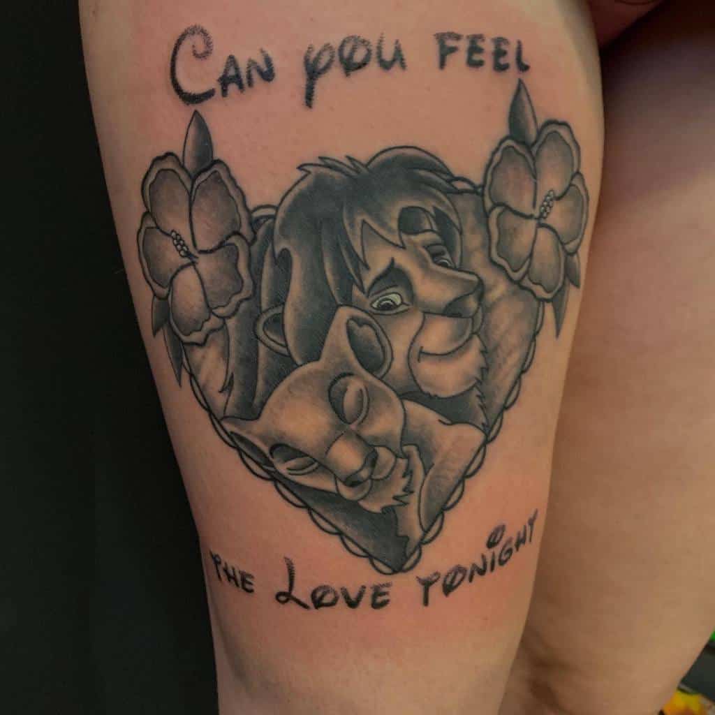 Tattoo of Nala and Simba snuggling inside a heart with flowers, with the text "Can you feel the love tonight" above and below