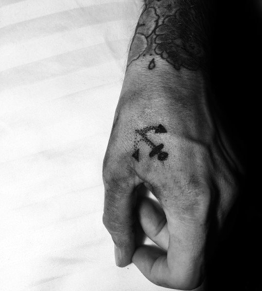 Small and minimalist anchor tattoo on the hand, featuring a bold black design that symbolizes strength, stability, and a nautical connection.