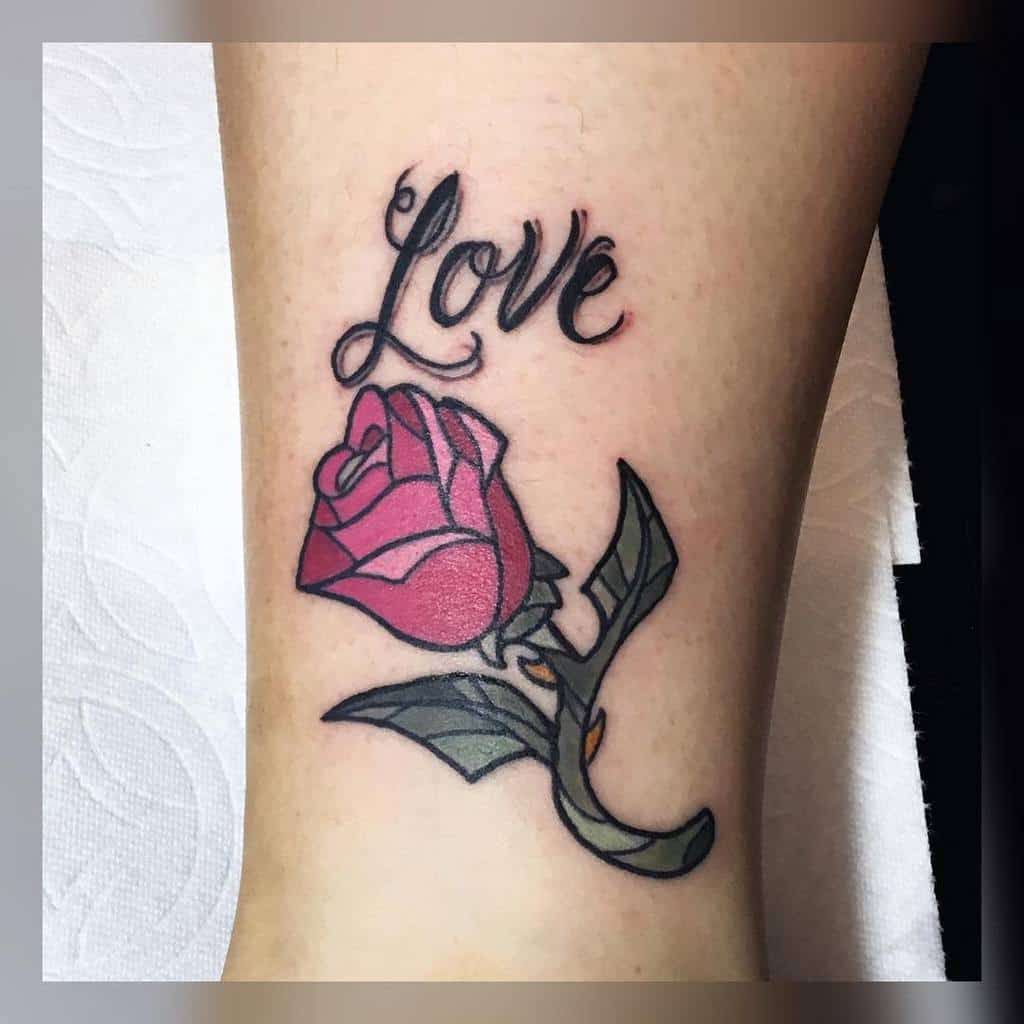 Tattoo of the word "Love" above a red rose with green leaves
