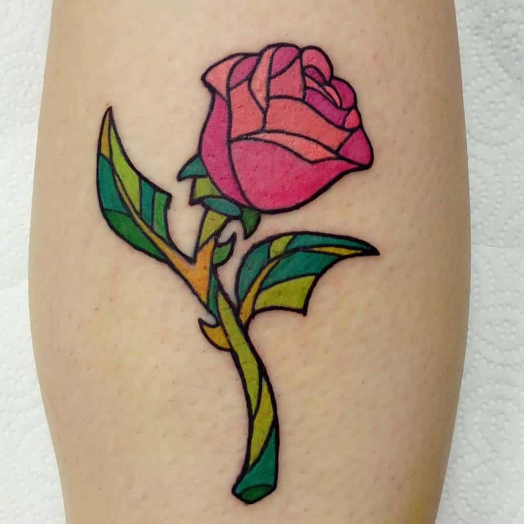 Colorful stained glass style tattoo of a pink rose on skin