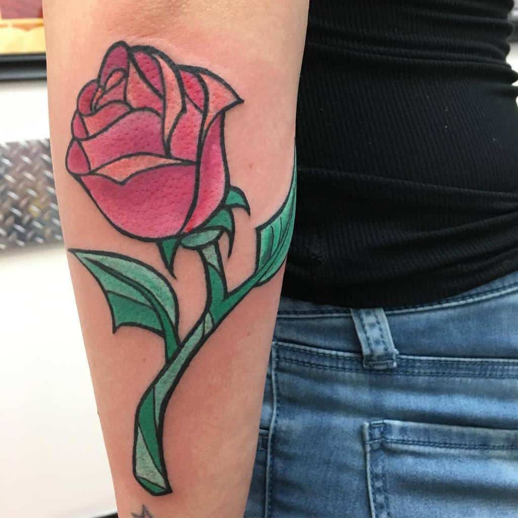 Close-up of a colorful rose tattoo on a forearm