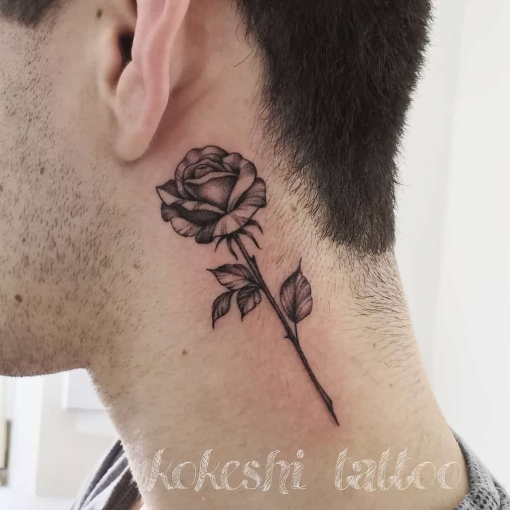 A neck tattoo featuring a meticulously detailed black and gray rose design