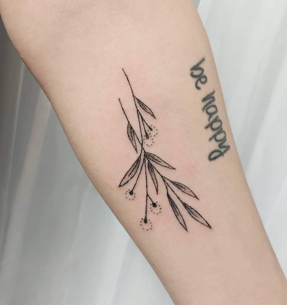 This tattoo showcases a minimalist design of delicate leaves and seeds, with a fine line style and subtle dotwork. It conveys a peaceful and natural aesthetic, complementing the 'be happy' quote alongside it. The composition is graceful and understated.