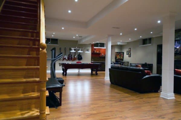 Man cave basement with pool table, guitar wall display, and leather seating area.