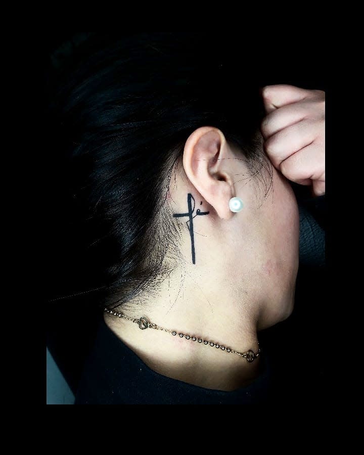 Woman with cross tattoo behind her ear