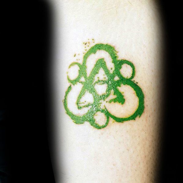 Green Keywork tattoo inspired by Coheed and Cambria, featuring soft brushstroke lines and subtle splatter for a unique, earthy look.