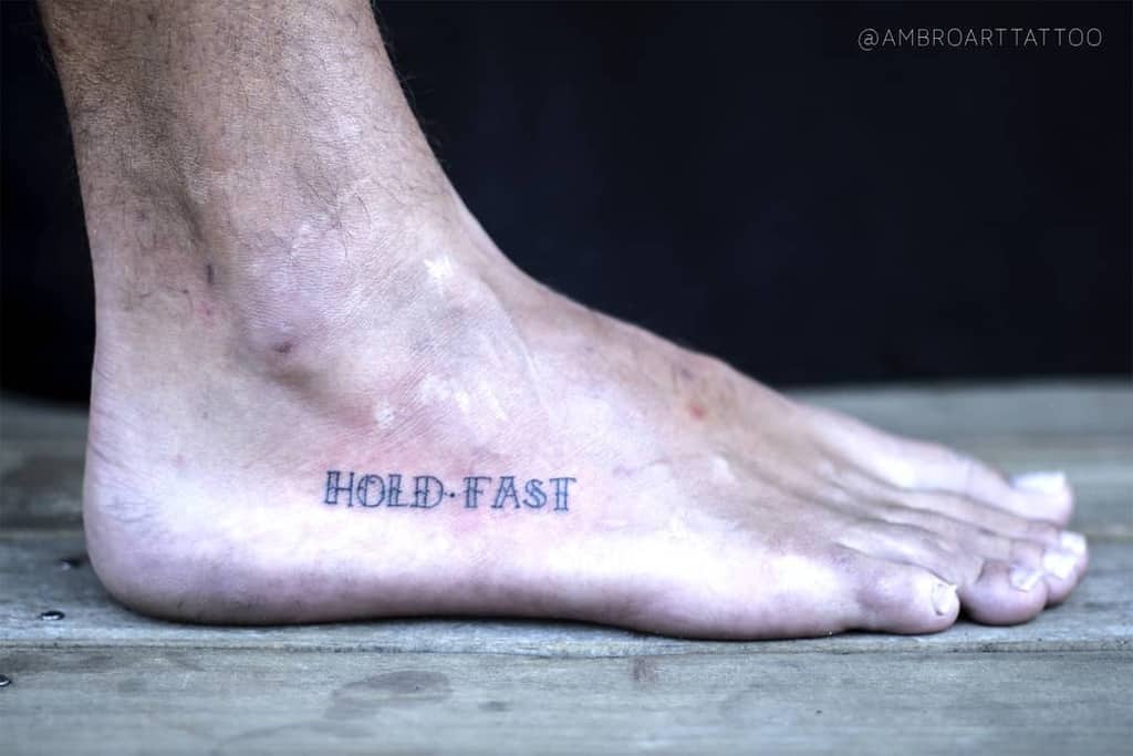 Tattooed foot with "HOLD FAST" text on the side