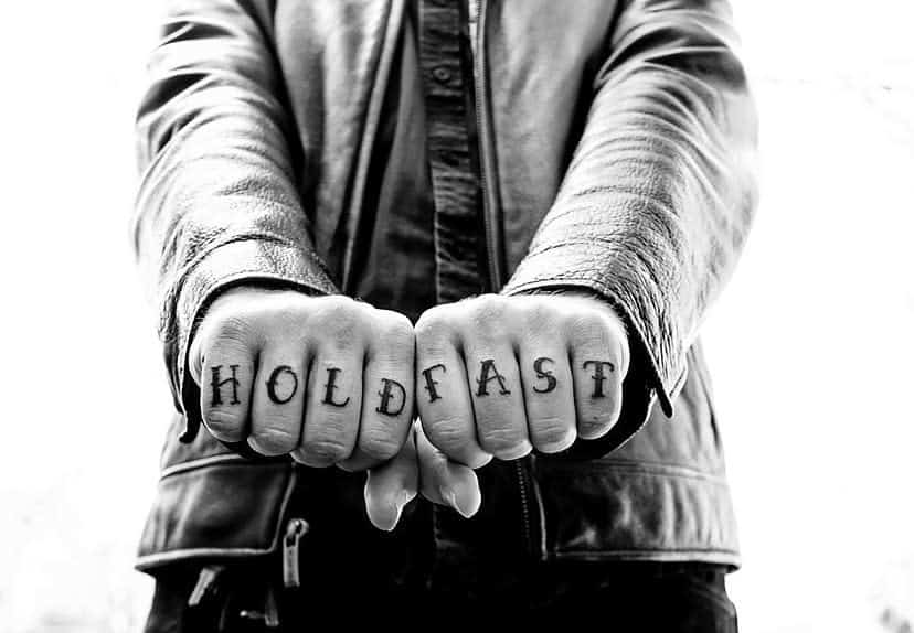 Man shows "HOLD FAST" tattooed on knuckles